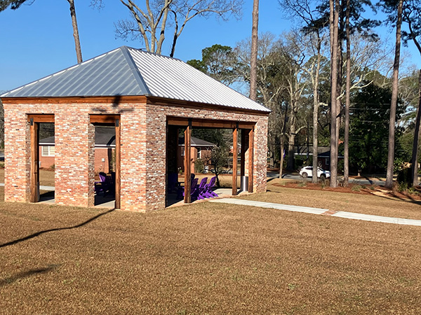 A side view of the Barrs Family Learning Pavilion featuring Adirondack chairs on the Cochran Campus.
